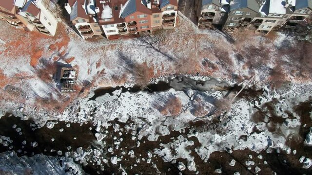 Aerial: River and chalets in the winter time. Avon, Colorado, USA