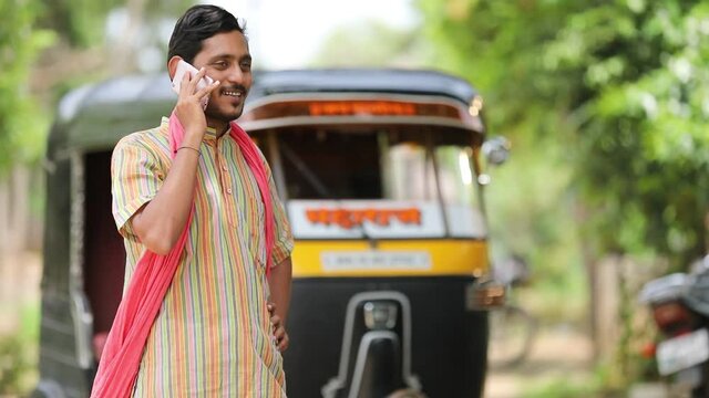 Indian auto rickshaw three-wheeler tuk-tuk taxi driver man talking on smartphone