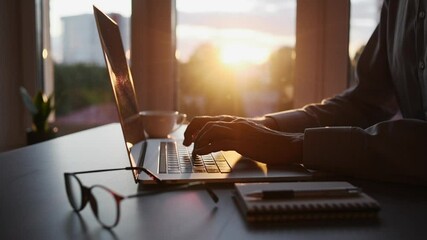 Businessman using laptop computer in the office. Young man student working at home at sunset. Online internet marketing, freelance, working from home, online education, studying concept