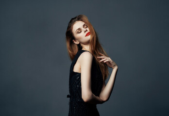 Fototapeta premium cheerful woman in a black dress fashion Lifestyle dark background