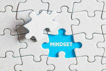 Fototapeta premium The word mindset on blue missing puzzle piece. To expose or discover mindset