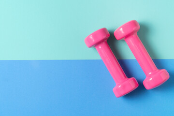 pink dumbbell and blue, green yoga mat on table, fitness healthy and sport concept