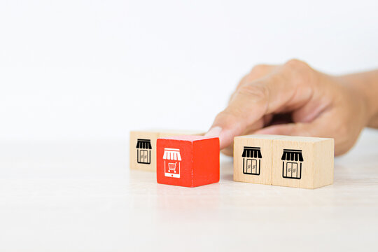 Franchise e-commerce, Hand choose cube wooden block stack with franchise business e-commerce store growth with graph icon for change financial marketing to online platform adjust to survive and grow.