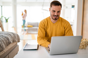 Handsome man designer working home using laptop at home