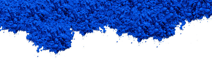 Blue pigment granules and powder strewn on the top of the photo, viewed from above on white. The pigment will be mixed with linseed oil to make oil paint. Widescreen