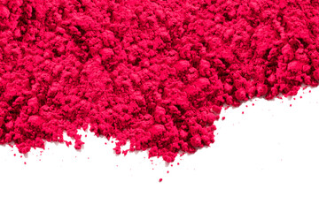 Red pigment granules and powder strewn on the top of the photo, viewed from above on white. The pigment will be mixed with linseed oil to make oil paint