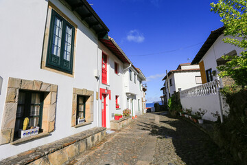 cobbled road between the houses of the fishing port of tazones in asturias, spain. sunny day.