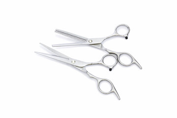 Two pairs of silver hairdressing scissors for hair cutting with isolated on white background.