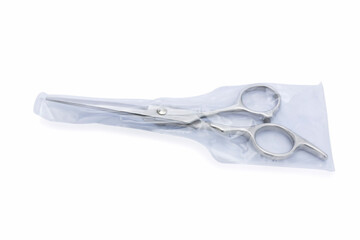 Plastic wrap for barber scissors. a silver hair cutting scissors with isolated on white background.