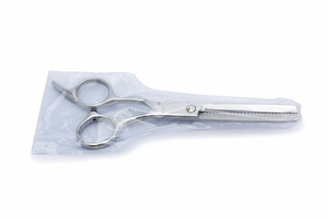 Plastic wrap for barber scissors. opened silver hair cutting scissors for hair filibustering with isolated on white background.
