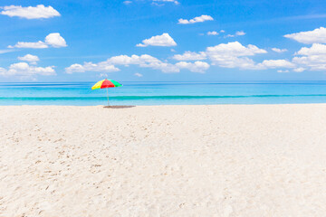 Fototapeta na wymiar A colourful umbrella on white beach.