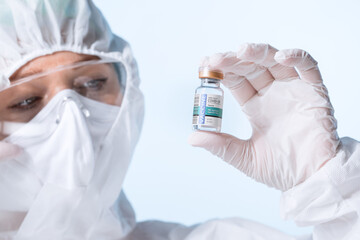 NO LOGOS OR TRADEMARKS!  SELF MADE LABELS! Close up view of doctor with an ampule of covid vaccine...