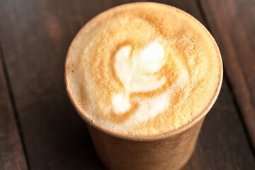 coffee in a paper cup on a wooden table