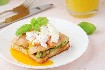 Breakfast with a sandwich with poached egg and avocado