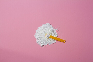 sports supplement creatine powder on pink background copy space