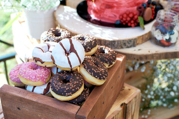 Mini donuts in a wooden box. Donuts in colored glaze
