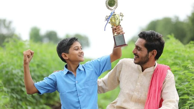 clever school boy holding winning trophy and celebrate with his father.
