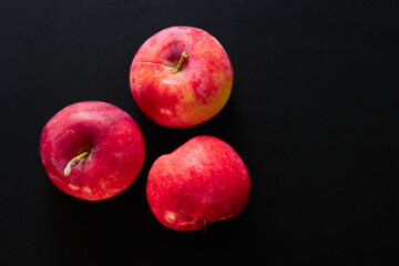 red organic apples on a black background