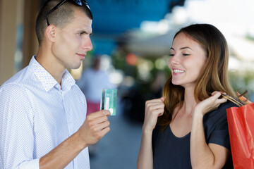 beautiful young girl asking boyfriend a credit card