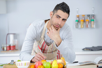 young man cutting fruit in the kitchen
