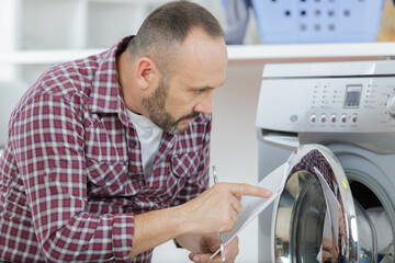 man with clipboard near washing machine
