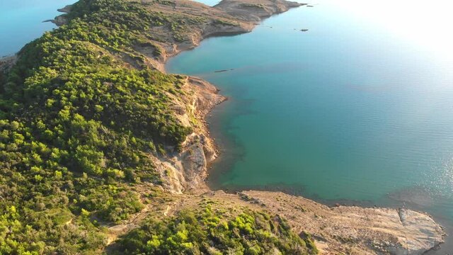 Drone footage of Rab Island, Lopar Area in Croatia. Early, calm morning after sunrise. Golden hour shoot with epic landscape, Adriatic blue sea and mountains.