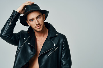 handsome man in leather jacket hat posing studio fashion