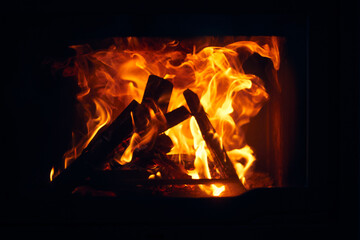 Fototapeta premium A fire burns in a fireplace, Fire to keep warm. Logs burning in a fireplace