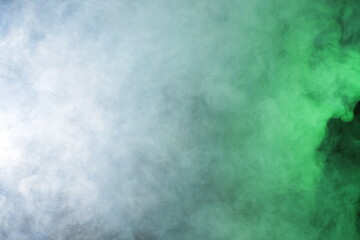 Fototapeta na wymiar Artificial smoke in grey-green light on black background