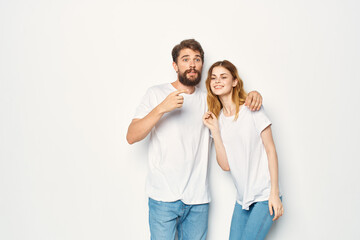 Fototapeta premium cheerful young couple in white t-shirts embrace friendship lifestyle