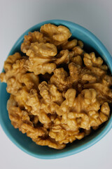 Walnuts in Blue Bowl White Background Vertical Close Up Bird's Eye View