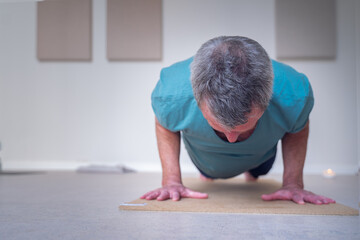 Frontal photo of a mature man doing push-ups