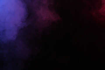 Obraz na płótnie Canvas Artificial magic smoke in red-blue light on black background