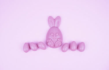 Composition of chocolate figurines. Chocolate bunny. Chocolate eggs on a colored background. Place for the test.