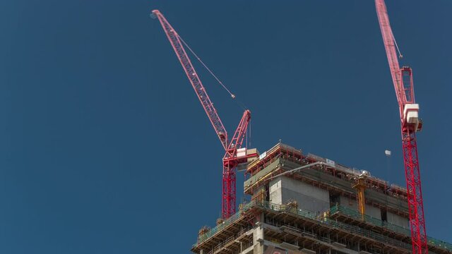 High multi-storey buildings under construction and cranes timelapse