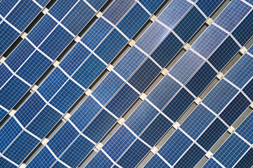 Aerial view of solar power plant with blue photovoltaic panels mounted on industrial building roof...