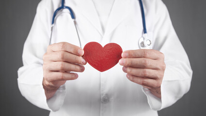 Doctor with stethoscope holding red heart.