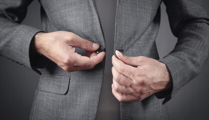 Man fastening buttons on suit. Fashion