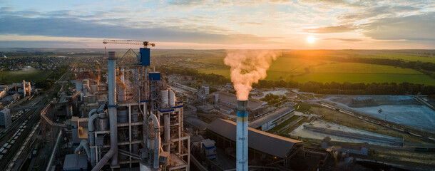 Aerial view of cement factory tower with high concrete plant structure at industrial production...