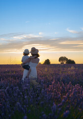 Fototapeta na wymiar mother and son at sunset in lavender field