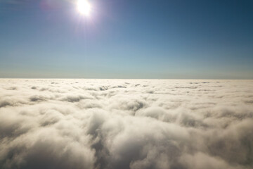 Aerial view from above of white puffy clouds.