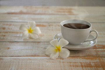 Fototapeta na wymiar lumeria flowers with Espresso or americano, black coffee cup on a wooden floor. warm tone,