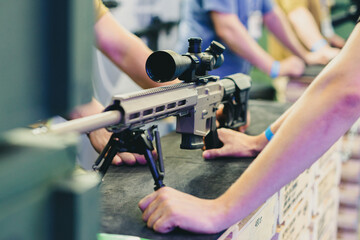 Man holding an automatic rifle with a telescopic sight