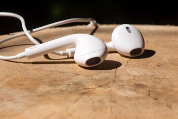 White modern  earphones, headset, on wood table