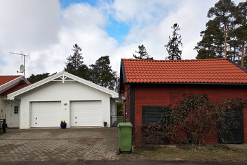 Fototapeta na wymiar White new garage for two cars and wooden barn on private house yard.
