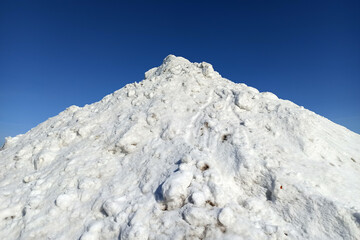High pile of white snow on winter sunny day.