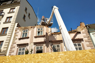 Tower of lift crane and old building under dismantling.