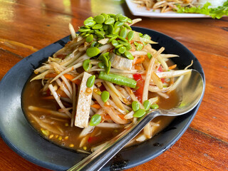 Thai spicy papaya salad Som Tam with pepper sausage