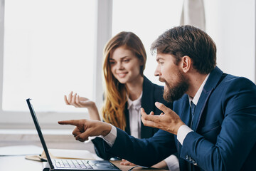 colleagues sitting at a desk with a laptop communication professionals