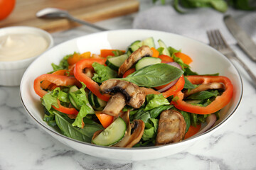 Bowl of delicious salad on white marble table, closeup